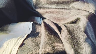 Siyah perdelerin üzerindeki bant. Geniş beyaz bir şerit. Perdeleri korsese asmak için bir bant. İç mekan. Daire dekorasyonu. Hafif endüstri.