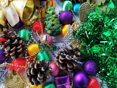 Noel süsü koleksiyonu. Güzel düzenlenmiş parlak Noel ağacı süslemeleri, yeşil folyo, hediyeler. Yeni yıl ve Noel için kırmızı, mor, sarı renkli dekor unsurları.