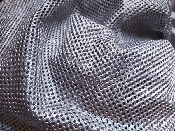 穴のある合成ポリエステル生地 抽象的な背景 灰色又は銀色の織物の波状部分 — ストック写真