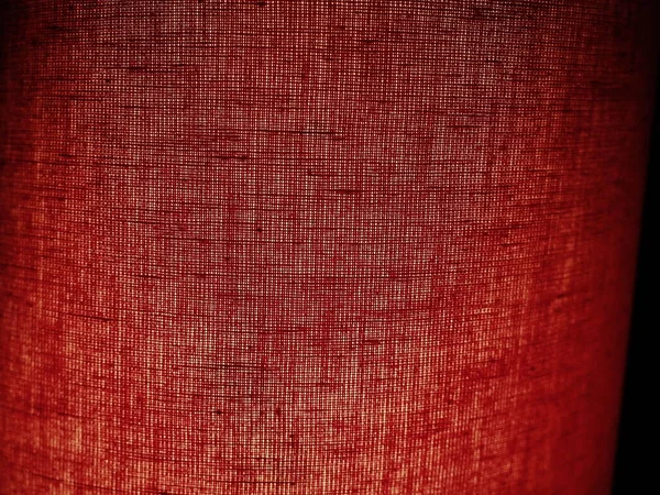 Red abstract background made of fabric. Macro image. Weaving tap-colored pits with black shadows and vignettes. Background for Christmas, New Year, Valentines Day — Stock Photo, Image