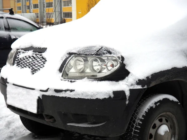 snow-covered car. The car is parked after a snowstorm. Winter time in the north. Snow on the vehicle