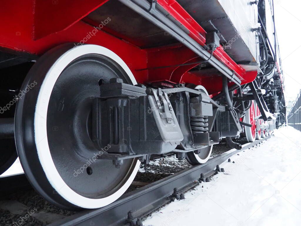 retro train. Locomotive of the 19th early 20th century with a steam engine. Vintage style. Black train with red wheels. Metal cast iron parts. Levers, engines, fences, boilers, pipes of the train.