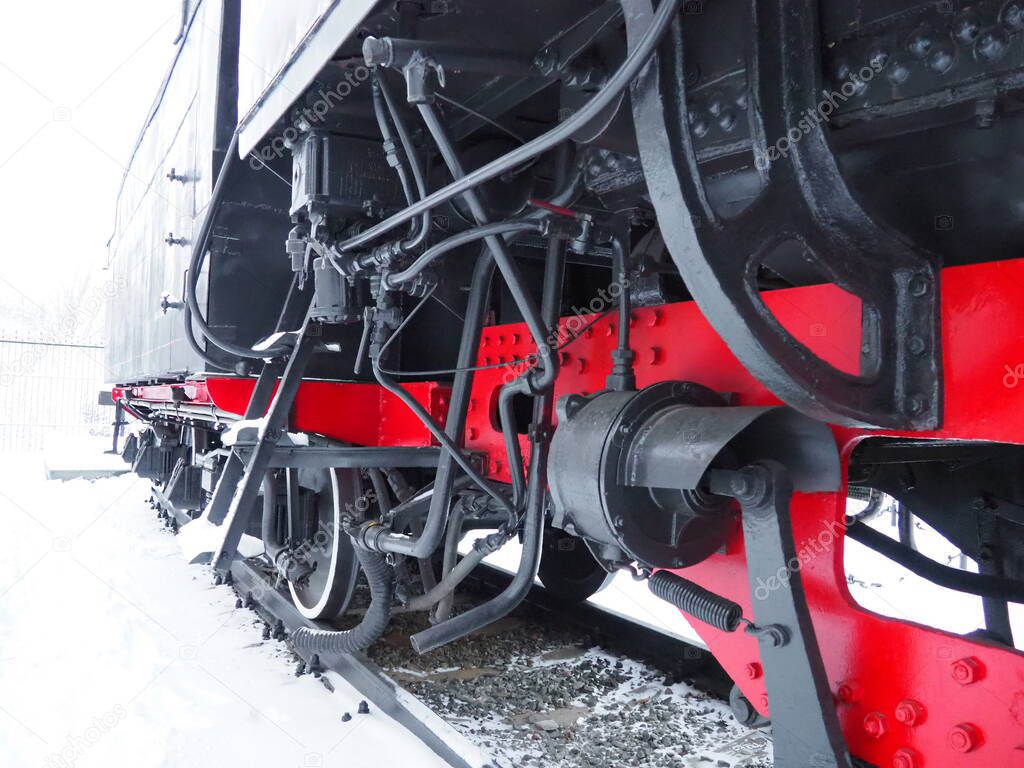 retro train. Locomotive of the 19th early 20th century with a steam engine. Vintage style. Black train with red wheels. Metal cast iron parts. Levers, engines, fences, boilers, pipes of the train.