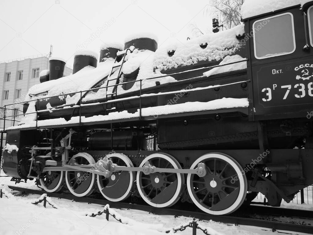 retro train. Locomotive of the 19th early 20th century with a steam engine. Vintage style. Black train with red wheels. Metal cast iron parts. Levers, engines, fences, boilers, pipes of the train.