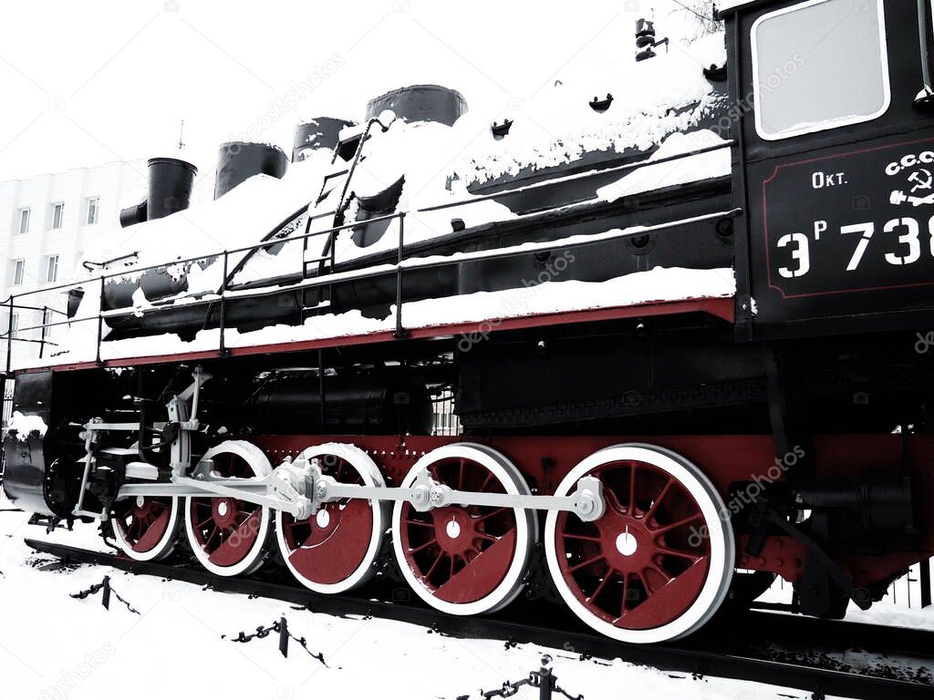 retro train. Locomotive of the 19th early 20th century with a steam engine. Vintage style. Black train with red wheels. Metal cast iron parts. Levers, engines, fences, boilers, pipes of the train.