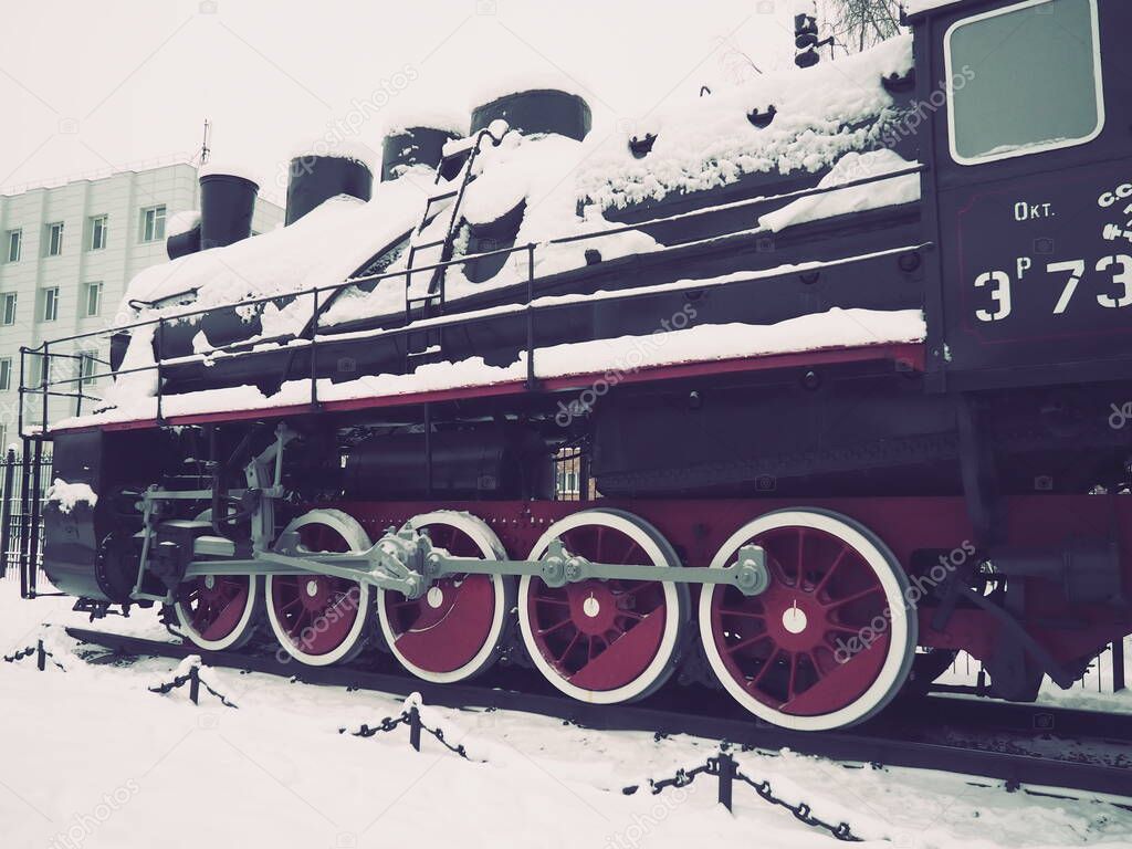 retro train. Locomotive of the 19th early 20th century with a steam engine. Vintage style. Black train with red wheels. Metal cast iron parts. Levers, engines, fences, boilers, pipes of the train.