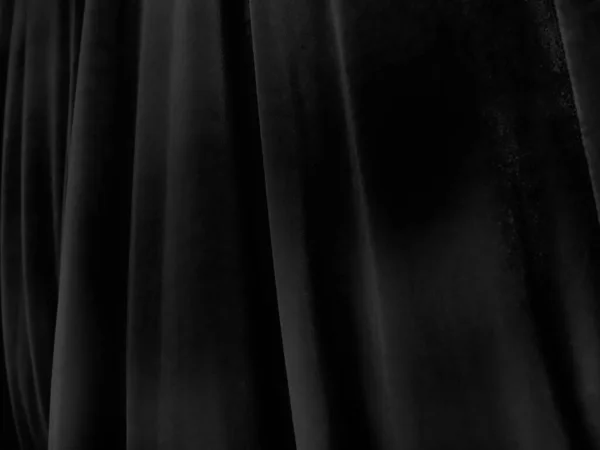 Soft waves on black velvet curtains. Stylized defocused image. Dark draperies made of pleasant fabric. Pleats on the curtains. Abstract black and gray background