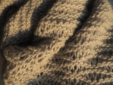 Toplu poliakrilik bej ya da kahverengi iplikten örülmüş bir ürün. Lüks makine kutusu. Sonbahar-kış dönemi için sıcak bir gardırop seçeneği. Sıcak atkı, kazak ya da kazak..