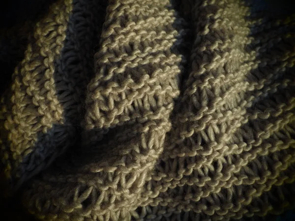 かさばる茶色または灰色の糸からのニットスカーフ。ラッシュマシン編み物。秋冬期間中の暖かいワードローブのためのオプション。フロント、プルループでニット。居心地の良い家｜静物 — ストック写真