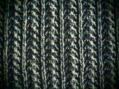 Örülmüş yeşil iplik deseni. Pürüzsüz makine ya da el örgüsü. Sonbahar-kış dönemi için sıcak gardırop. Öne dokuma, mor düğümler. Örgü metodu - dalgalı elastik.