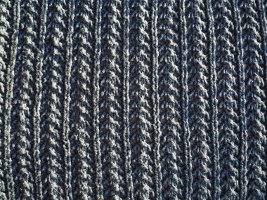 Örülmüş mavi iplik deseni. Pürüzsüz makine ya da el örgüsü. Sonbahar-kış dönemi için sıcak gardırop. Öne dokuma, mor düğümler. Örgü metodu - dalgalı elastik.