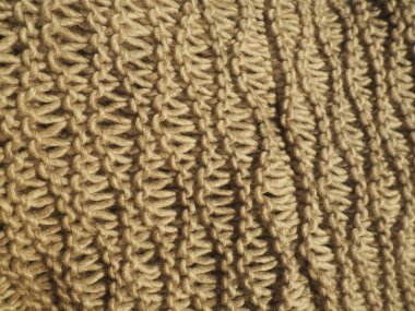 Kahverengi ya da bej renkli iplik desenleri. Pürüzsüz makine ya da el örgüsü. Sonbahar-kış dönemi için sıcak gardırop. Öne dokuma, mor düğümler. Örgü metodu - dalgalı elastik.