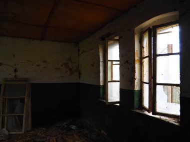 Korkunç pencereler. Terk edilmiş bir evde. Perdesiz kırık pencerelerin görüntüsü. Grunge sahnesi. Kırık camlarla eski ahşap çerçevelerden ışık saçar. Terk edilme ve işe yaramazlık kavramı..