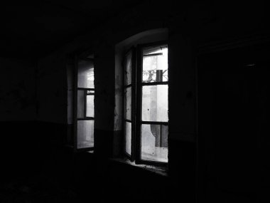 Korkunç pencereler. Terk edilmiş bir evde. Perdesiz kırık pencerelerin görüntüsü. Grunge sahnesi. Kırık camlarla eski ahşap çerçevelerden ışık saçar. Terk edilme ve işe yaramazlık kavramı..