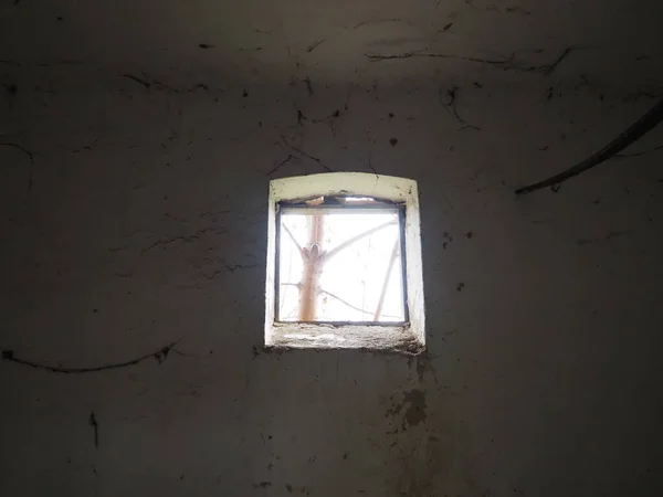 壁の上部には小さな窓があり そこから光が出てくる クモの巣で怖い壁 古い教会のドーマー ハロウィンかお化け屋敷か 拷問ロープを持った刑務所の独房だ 幻視と幻覚の世界 — ストック写真