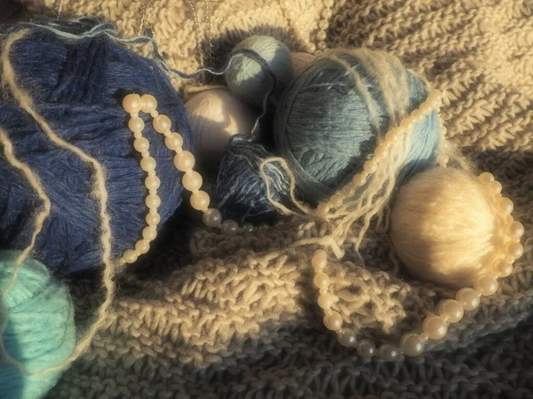ニット製品の背景に糸や糸のカット ウール糸とアクリル糸のベージュとブルーの色 パールビーズはボールに横たわっている 静物画 — ストック写真