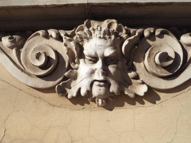 Bir binanın ön cephesinde rahatlama ayrıntıları. Stucco kıvırcık saçlı, bıyıklı ve kıvırcık saçlı bir erkek kafası şeklinde. Sremska Mitrovica, Sırbistan. Ön cephede dekoratif detay