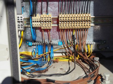 Kabloları, bağlantıları, terminalleri olan elektrik tertibatı. Elektrik voltajlı bir çekmeceyi aç. Kablo siyah elektrik bandına sarılı. Güç arzı ve bilgisayar sunucu teknolojisi