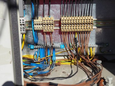 Kabloları, bağlantıları, terminalleri olan elektrik tertibatı. Elektrik voltajlı bir çekmeceyi aç. Kablo siyah elektrik bandına sarılı. Güç arzı ve bilgisayar sunucu teknolojisi