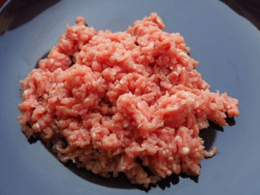 Mor seramik tabakta kıyma. Pirzola, biftek, hamburger, köfte yapmak için taze et. Domuz eti yarı bitmiş ürünler..