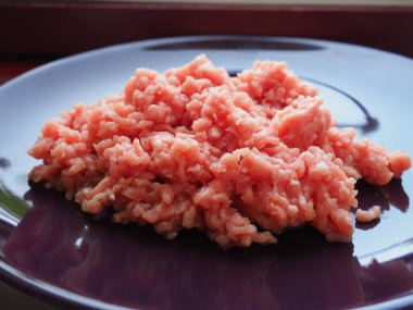 Mor seramik tabakta kıyma. Pirzola, biftek, hamburger, köfte yapmak için taze et. Domuz eti yarı bitmiş ürünler..