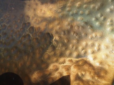 Metal bronz kaplama. Bronz ya da bakır cilalı yüzeyde göçükler, çizikler ve çukurlar var. Metal doku.