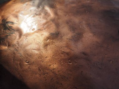 Metal bronz kaplama. Bronz ya da bakır cilalı yüzeyde göçükler, çizikler ve çukurlar var. Metal doku.