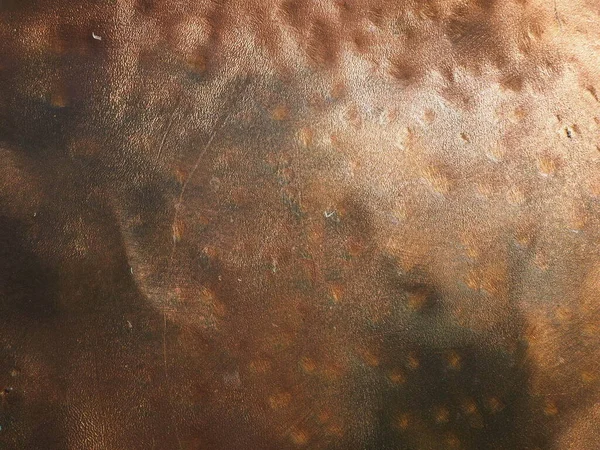 Metal bronze textured plate. Bronze or copper polished surface with dents, scratches and indentations. Metal texture.