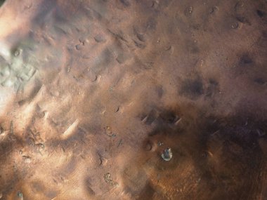 Metal bronz kaplama. Bronz ya da bakır cilalı yüzeyde göçükler, çizikler ve çukurlar var. Metal doku.