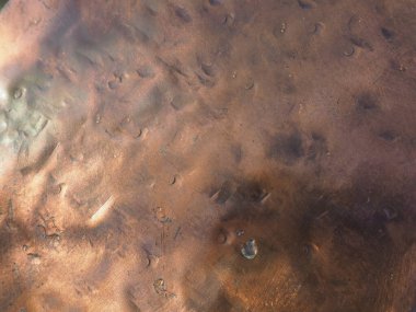 Metal bronz kaplama. Bronz ya da bakır cilalı yüzeyde göçükler, çizikler ve çukurlar var. Metal doku.