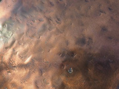 Metal bronz kaplama. Bronz ya da bakır cilalı yüzeyde göçükler, çizikler ve çukurlar var. Metal doku.