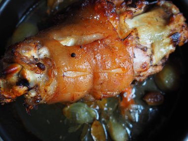 Soğan, havuç ve baharatla fırında pişirilmiş domuz budu. Lezzetli bir restoran ya da şenlikli bir öğle ya da akşam yemeği için ev yapımı yemek. Yağlı, yüksek kalorili erkek yemeği. Fırın pişmiş et..