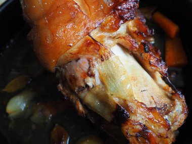 Soğan, havuç ve baharatla fırında pişirilmiş domuz budu. Lezzetli bir restoran ya da şenlikli bir öğle ya da akşam yemeği için ev yapımı yemek. Yağlı, yüksek kalorili erkek yemeği. Fırın pişmiş et..