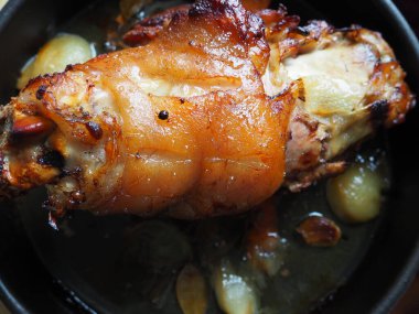 Soğan, havuç ve baharatla fırında pişirilmiş domuz budu. Lezzetli bir restoran ya da şenlikli bir öğle ya da akşam yemeği için ev yapımı yemek. Yağlı, yüksek kalorili erkek yemeği. Fırın pişmiş et..