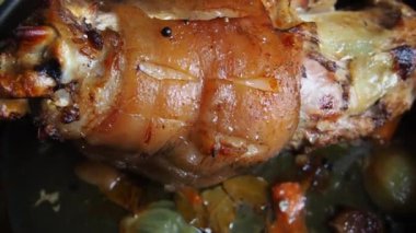 Soğan, havuç ve baharatla fırında pişirilmiş domuz budu. Lezzetli bir restoran ya da şenlikli bir öğle ya da akşam yemeği için ev yapımı yemek. Yağlı, yüksek kalorili erkek yemeği. Fırın pişmiş et..
