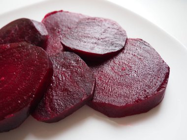 Beyaz bir tabakta pancar. İç dokusu, damarları ve nemli yüzeyi olan pancar kupaları. Vejetaryen ya da sebze sağlığı menüsü. Sebzeli sağlıklı yiyecekler. Parlak bordo ya da kırmızı renk