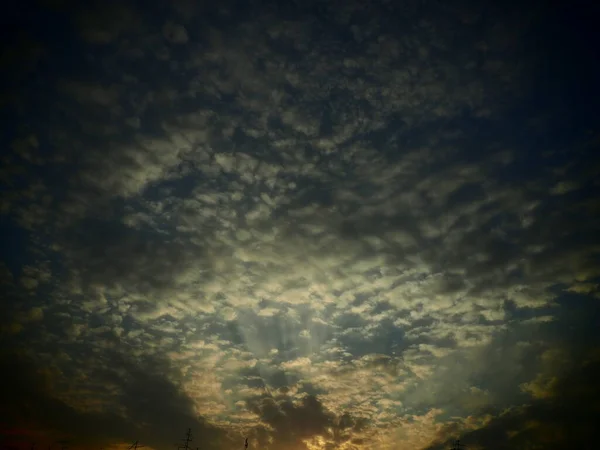 Black, green and yellow sunset sky cloud. Dramatic sunset sky. Wonderful sunset. Clouds in the evening sky. The sun\'s rays pierce the clouds. Beautiful landscape. The sun goes down. Vignetting