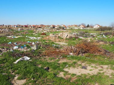Köyün yakınındaki çöplükte. Karmaşık gayri resmi çöplük. Plastik, torbalar, kağıt, cam, biyolojik atık. Toprağın yanındaki yeşil çimenler. Ekolojik felaket Sremska Mitrovica, Chalma, Sırbistan, 5 Nisan 2021.