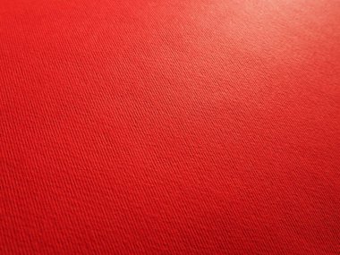 Soyut kırmızı arkaplan ve doku. Işık ve renk eğimine sahip kağıt yüzeyine yakın çekim. Yan ışıklandırma. Parlak kırmızı arkaplan.