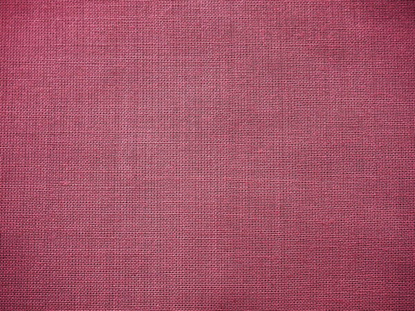 Ткань крупным планом. Переплетение нитей. Кусок розовой ткани. Ткань фона. Копирование пространства.