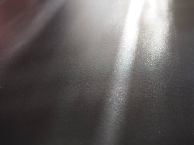 Gri yüzeyde aydınlatma ışınları. Gri bir arkaplanda soyut ışık ve mercek ışınları parlar. Dikey, yatay ve köşegen ışık çizgileri.