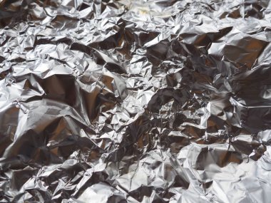 Folyo yakın plan. Alüminyum gümüş buruşuk folyo. Soyut metalik arka plan. Yemek pişirmek için folyo. Arkaplan.