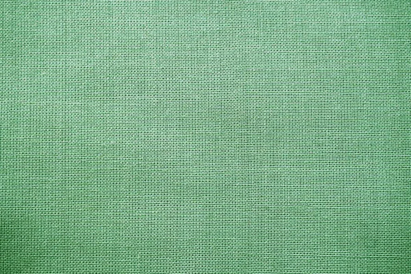 Textura de tecido verde natural close-up. A textura do tecido é feita de algodão natural ou material têxtil de linho. Fundo de tela verde. Superfície lisa, tecido alisado — Fotografia de Stock