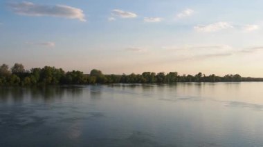 Sava Nehri, Sırbistan ve Sremska Mitrovica 'da su akışı. Suyun yüzeyinde serinleyin. Fotoğrafçılık için altın saat. Ormanlı sahil. Güzel manzara. Balkan Yarımadası 'nın doğası