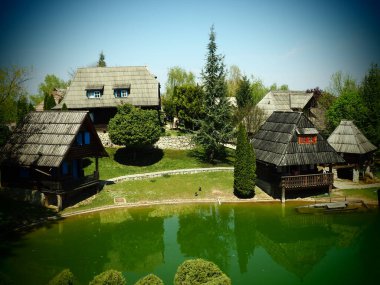 Stanisici, Bijelina, Bosna-Hersek. 25 Nisan 2021 Ethno köyü, Bosna tarzı dağlık bölgelerde kütüklerden yapılmış geleneksel köy evleri. Sulu göl. Ahşap mimari