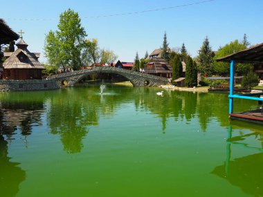 Stanisici, Bijelina, Sırp Cumhuriyeti, Bosna-Hersek, 25 Nisan 2021 Etno köyü, turizm ve turizm. Taş, ahşap binalar ve bir köprü. Yeşil suyu olan yapay gölet..