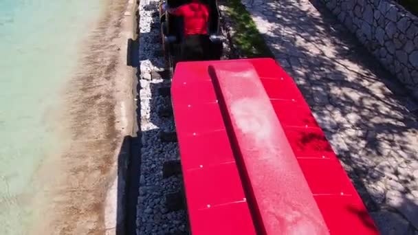 Stanisici, Bijelina, Bosnia y Herzegovina, 25 de abril de 2021. Una locomotora de vapor para niños con personas y niños conduce pasajeros. La locomotora y los vagones están pintados de rojo. Parque de atracciones de verano. Ferrocarril de juguete — Vídeos de Stock