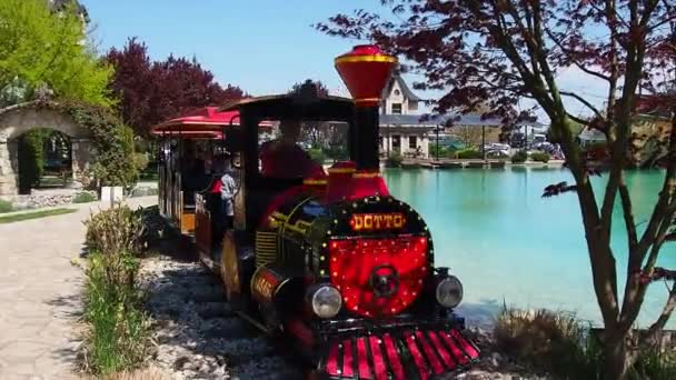 2021年4月25日，波黑比耶利纳Stanisici 。儿童蒸汽机车，由人和儿童驾驶。火车头和车厢漆成红色.夏季游乐园。玩具铁路 — 图库视频影像