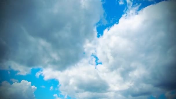 Λευκά και σκούρα σύννεφα πετούν γρήγορα κατά μήκος του γαλάζιου ουρανού. Ατμόσφαιρα χρόνου. Ο καιρός αλλάζει. Κίνηση των νεφών στον ουρανό. Ουράνιο φόντο — Αρχείο Βίντεο