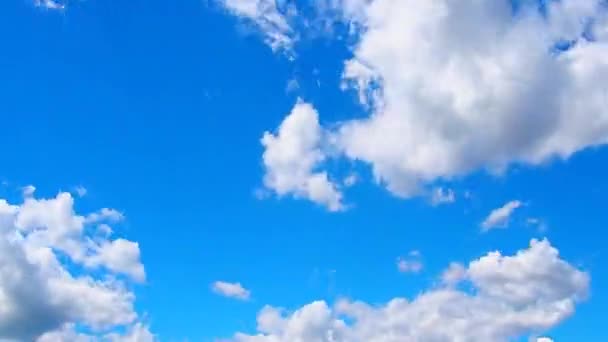 White and dark clouds fly rapidly across the blue sky. Time lapse atmosphere. Weather changes. Movement of clouds across the sky. Sky background — Stockvideo